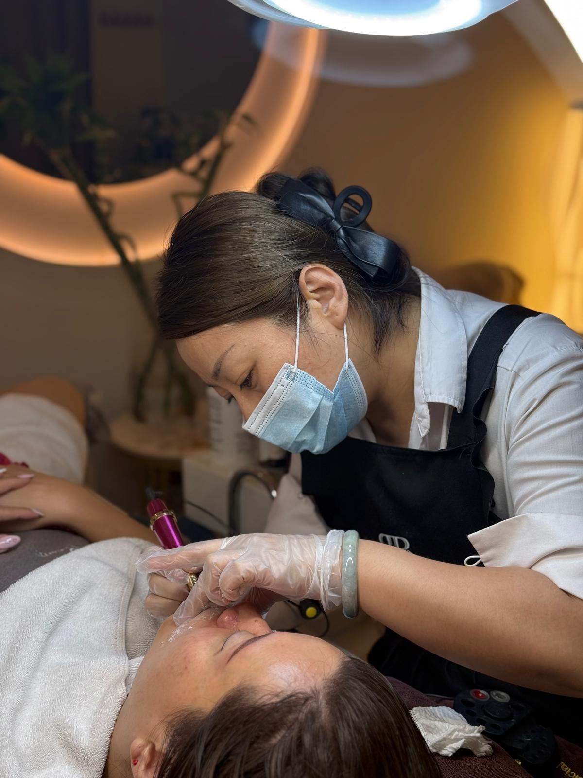 A specialist performing a treatment at Revitalized Beauty